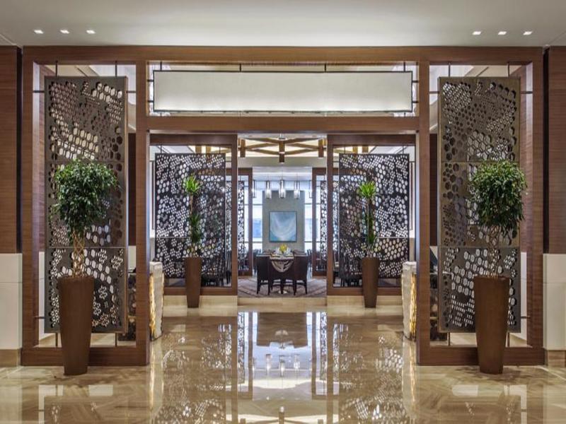 Hotel Jabal Omar Hyatt Regency Makkah Mekka Zewnętrze zdjęcie The photo depicts the interior of an elegant restaurant or lobby space. There are large decorative partitions that create a sense of separation and intimacy, featuring intricate designs. On either side of the partitions, there are tall decorative pla