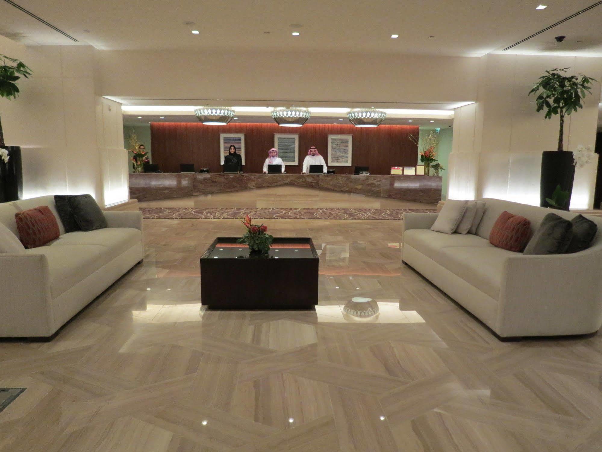 Hotel Jabal Omar Hyatt Regency Makkah Mekka Zewnętrze zdjęcie The photo shows a modern hotel lobby. In the foreground, there are two light-colored sofas with decorative pillows, positioned facing each other. A small coffee table with a plant sits between the sofas. 

In the background, there is a reception desk